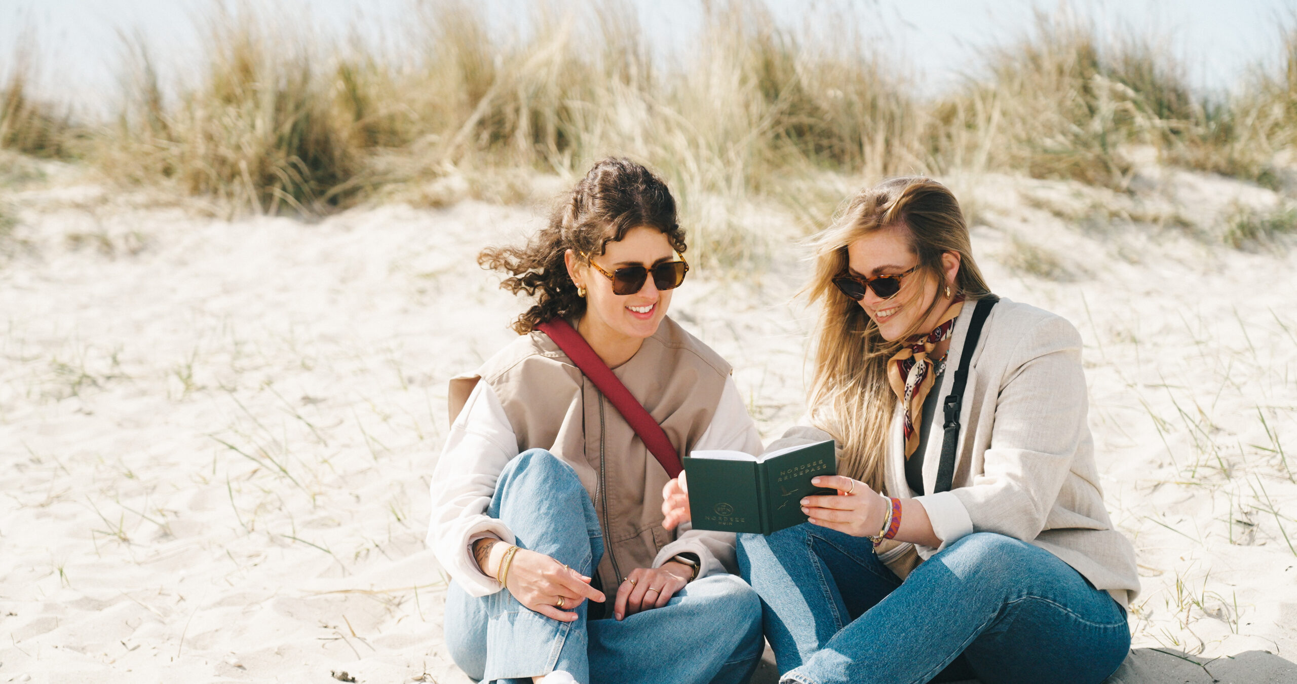 Stempelsammlerinnen mit dem Nordsee-Reisepass am Strand